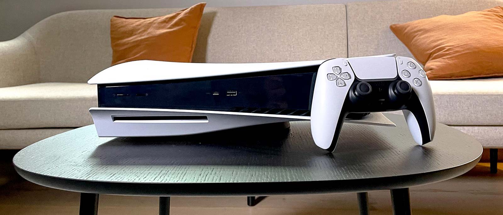 czarny kontroler DualSense leży na stole z widocznymi adaptive triggerami i haptic feedback