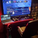 gracz przed telewizorem z kontrolerem ps5