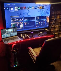 gracz przed telewizorem z kontrolerem ps5