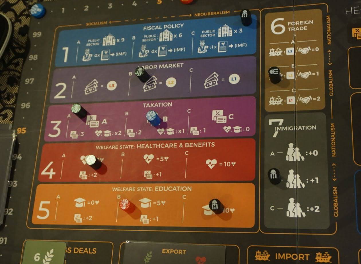 miniaturowe domy i fabryki na heksagonalnej planszy z punktami zwycięstwa