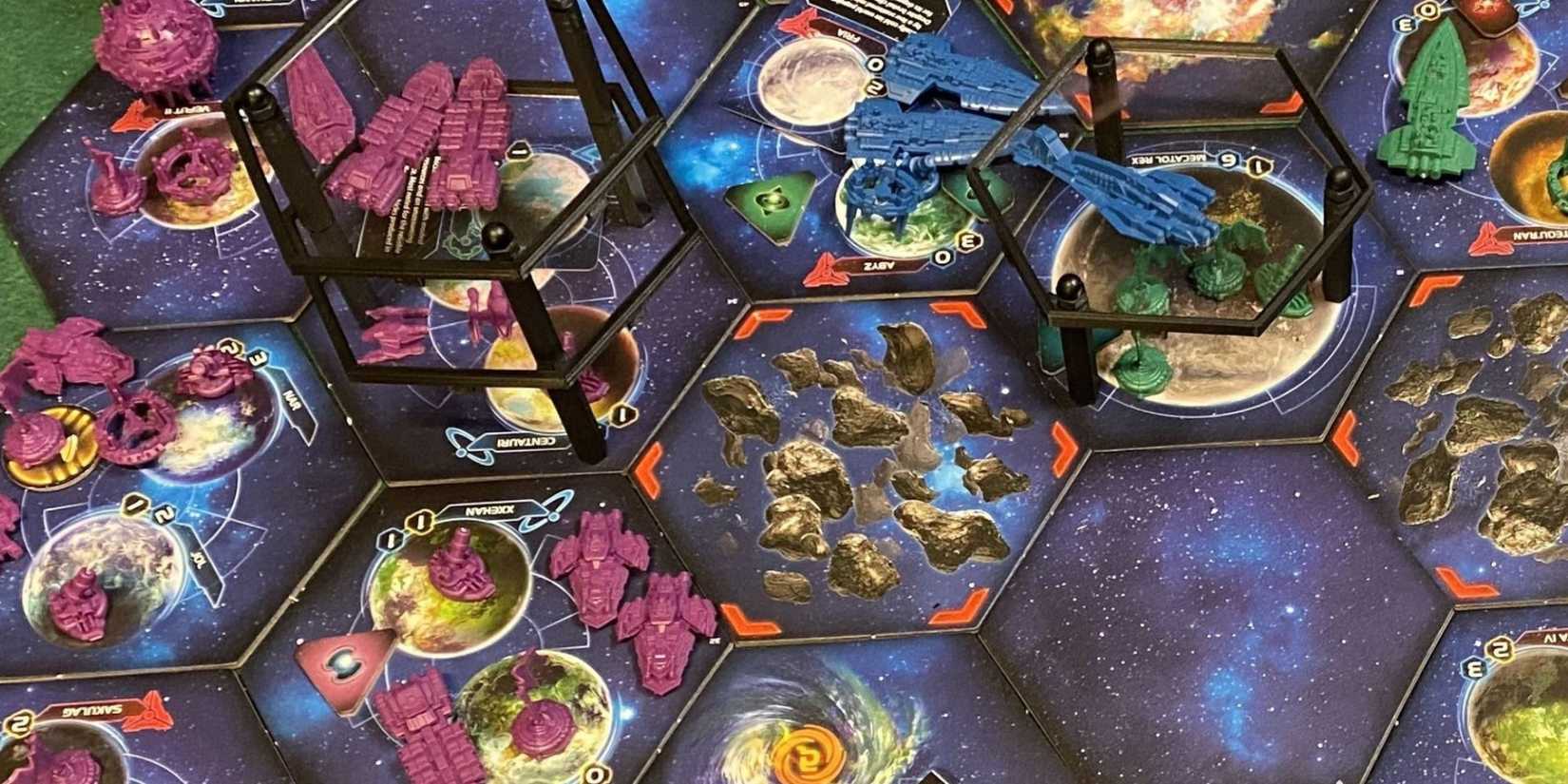 gracze układający galaktyczną mapę z kolorowymi statkami i żetonami imperiów kosmicznych