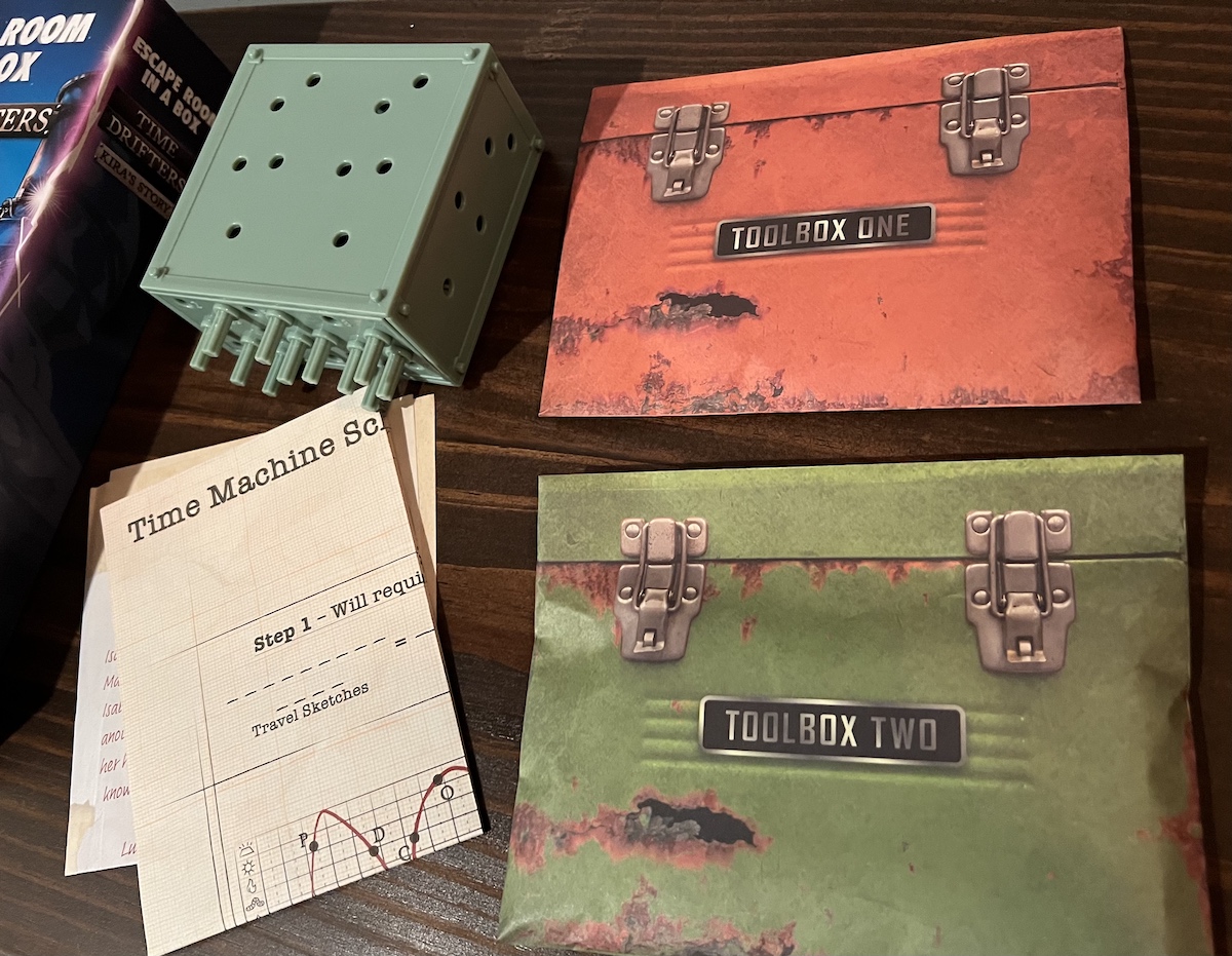 otwarte pudełko z kartami zagadek i kluczykami na drewnianym stole