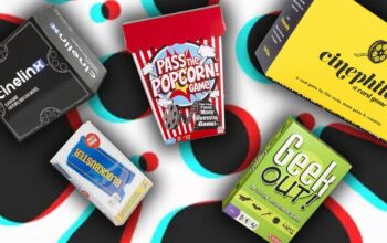 grupa przyjaciół grająca w planszówki z motywami filmowymi przy stole w salonie