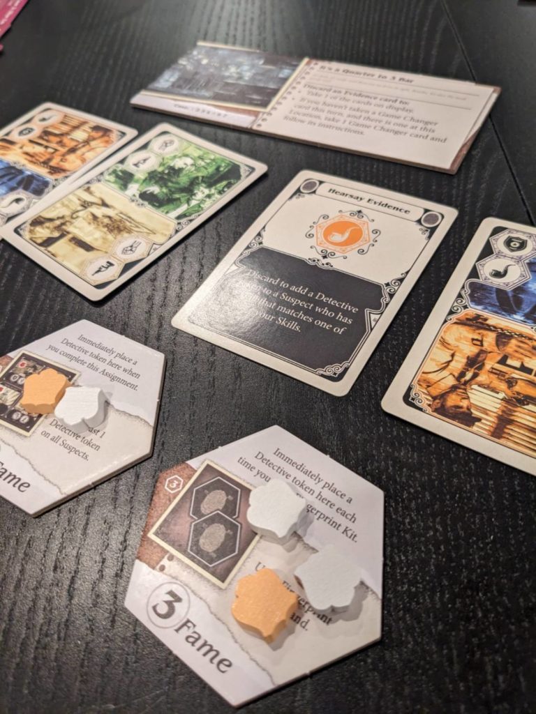 stos kart z zagadkami i znaczniki poszlak na drewnianym stole